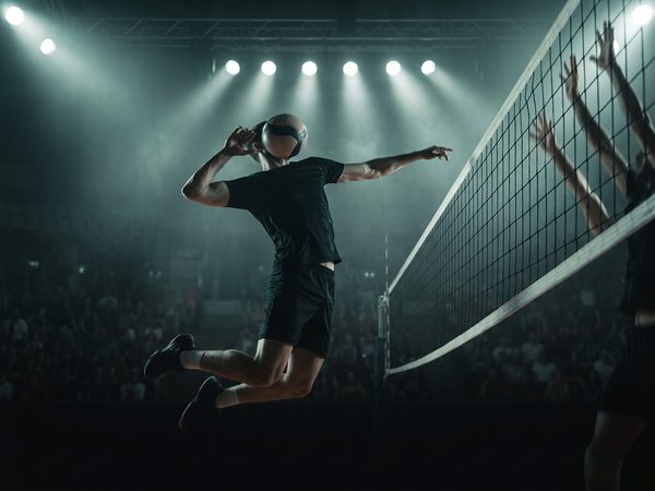 Volleyball player spiking the ball at the net